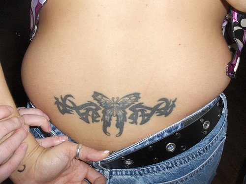 Tatuaggio non colorato sulla lombo in stile tribale & la farfalla
