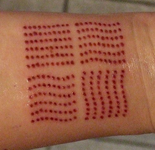 Tatuaggio sul polso il disegno rosso che fatto con i puntini