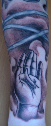 Tatuaggio grande colorato sul braccio la mano con la zhanna