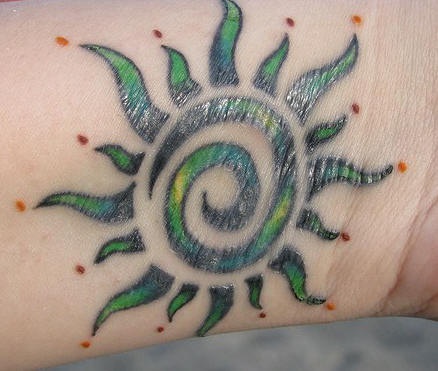 Sol en tinta verde estilo tribal tatuaje en la muñeca