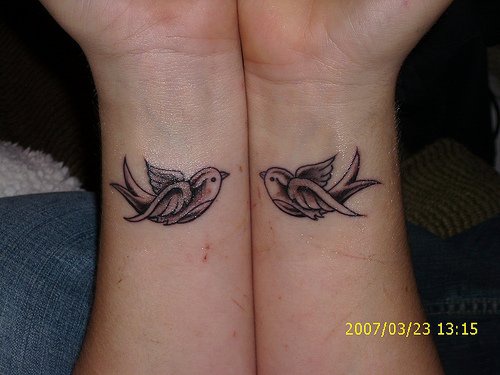 Le tatouage de deux poignets avec deux moineaux