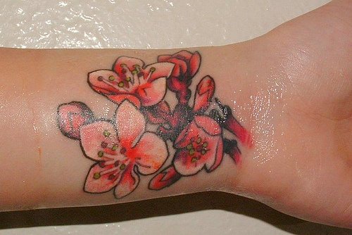 Red flowers and blossoms on inner side of wrist