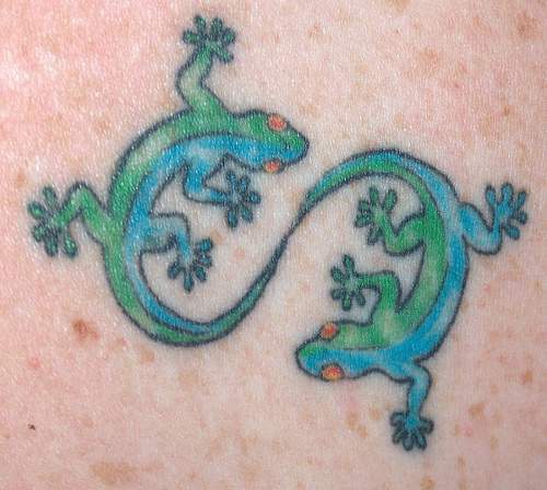 Yin and yang tattoo with green geckos