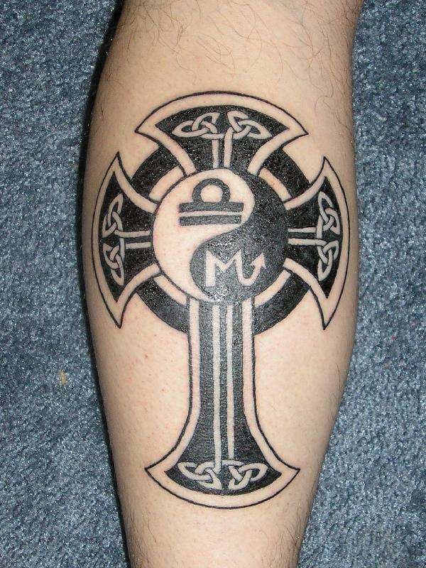 Black yin yang tattoo with a cross