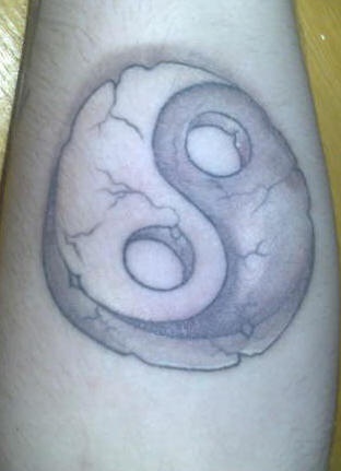 Volumetric yin yang tattoo in crushed stone style