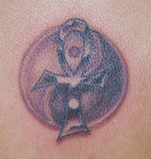 Tatuaje yin yang debajo de la cruz egíptica