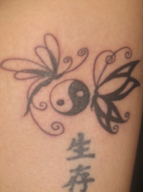 Tatuaje yin yang con dos mariposas y los  jeroglíficos