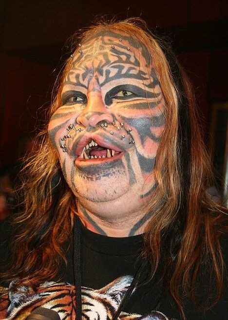 Tatuaje en la cara, araña negra estilizada