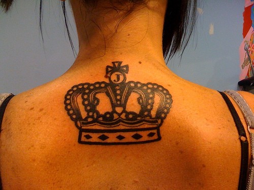 Tattoo on upper back black crown