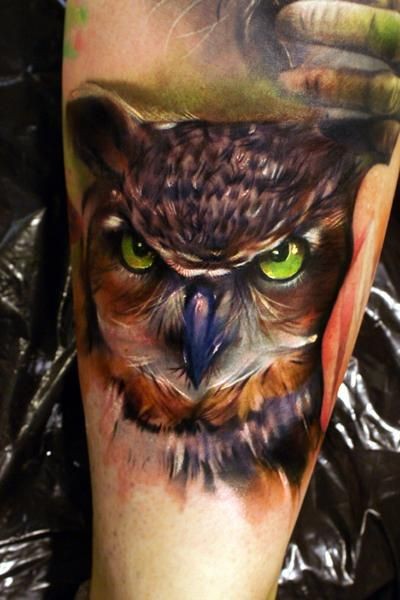 Tatuaggio grande sul braccio il gufo con gli occhi verdi