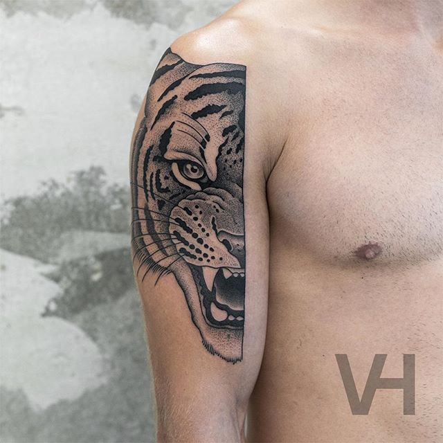 Tatuagem pintada por Valentin Hirsch no ombro da cara de tigre