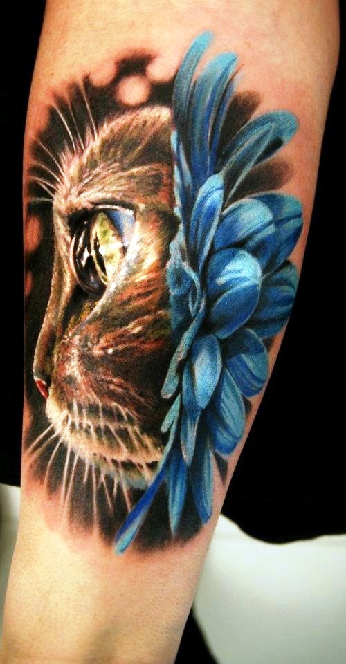 Tatuaje en el brazo, gato grande con flor azul