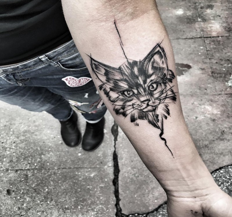 Tatuaggio disegnato da Inez Janiak con simpatica testa di gatto sull&quotavambraccio