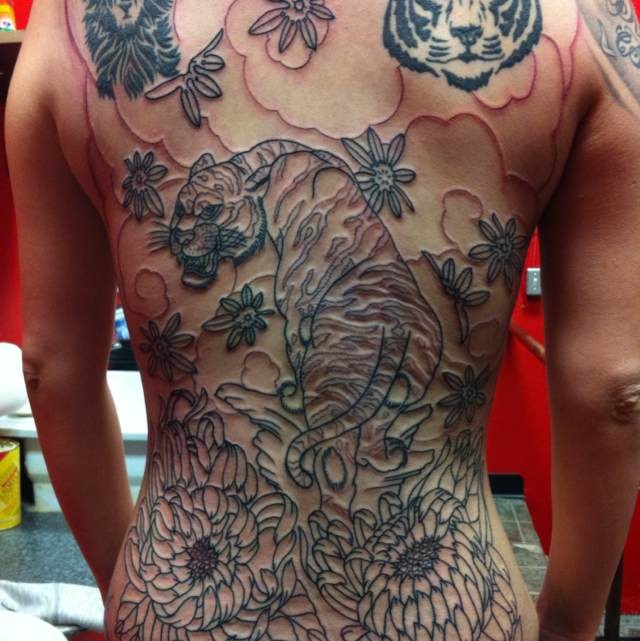 Tattoo mit Tiger und Blumen am ganzen Rücken