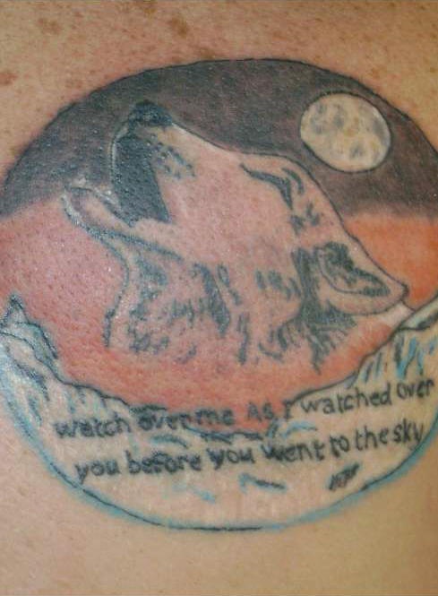 Tattoo with wolf howling and inscription