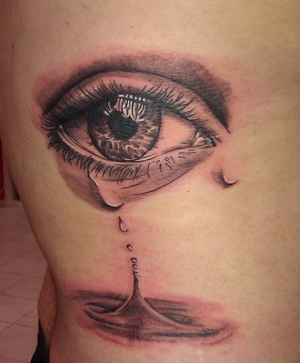 Tattoo mit tränigem Auge an den Rippen