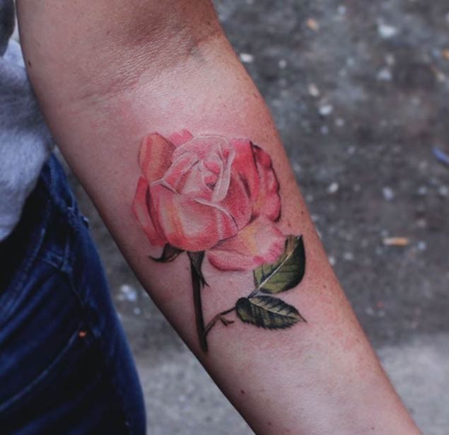 Tatuaje en el antebrazo, rosa delicada en tonos suaves