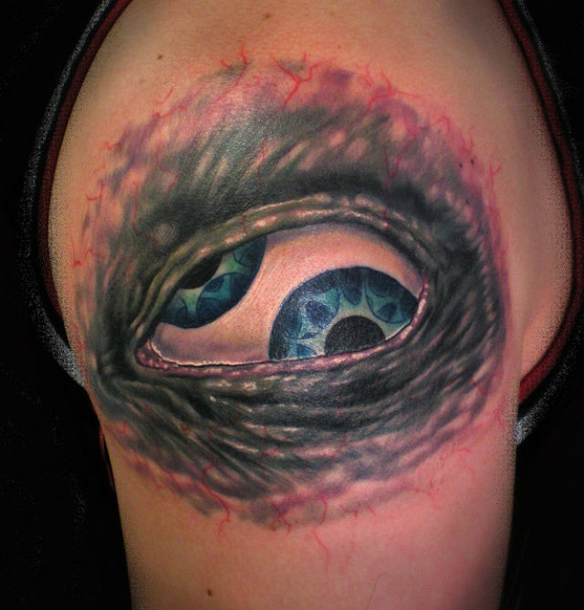 Tatuaje en el brazo, ojo tremendo con dos pupilas