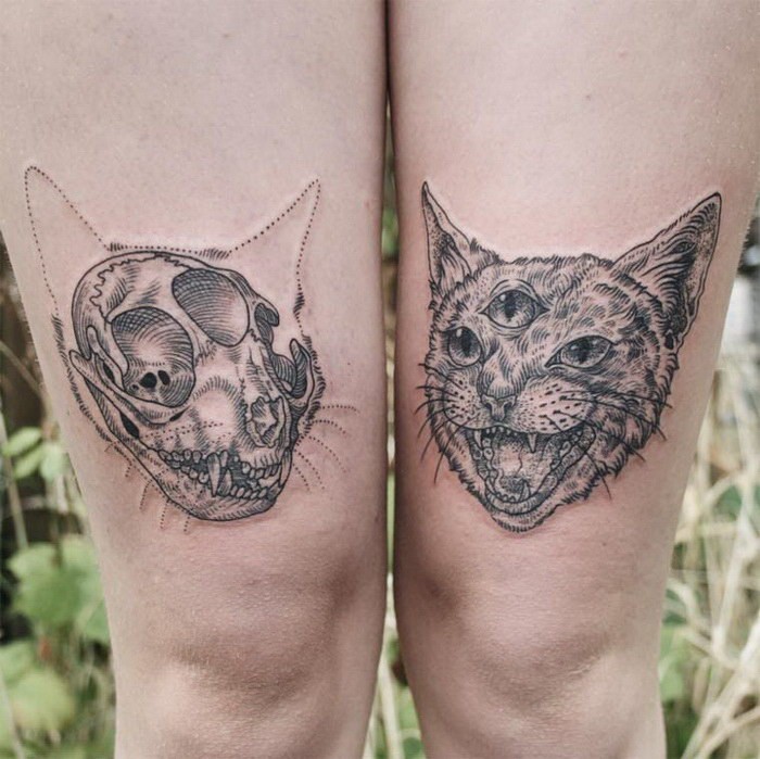 Terrifying black ink thigh tattoo of of cat skull with creepy cat with tree eyes