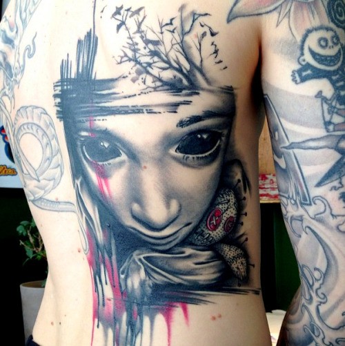 Terrifying colored mystical horror girl portrait tattoo on back combined with voodoo doll