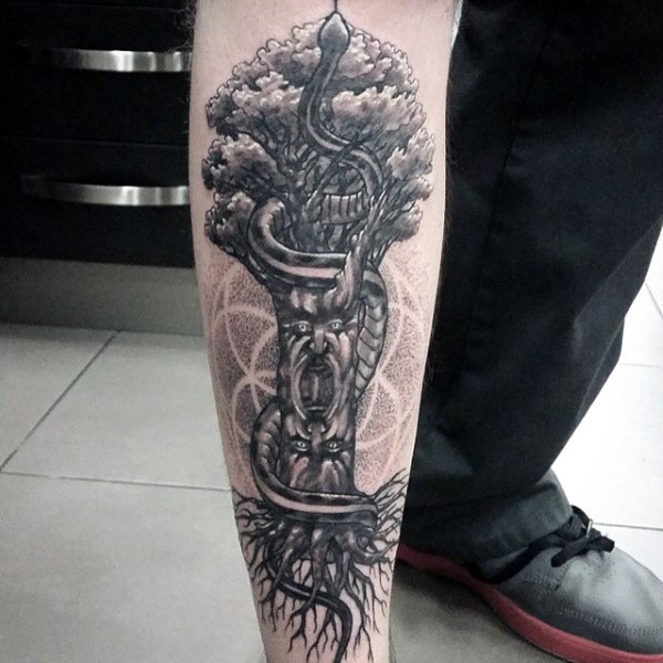 Terrifying looking big tree with faces tattoo on leg combined with snake