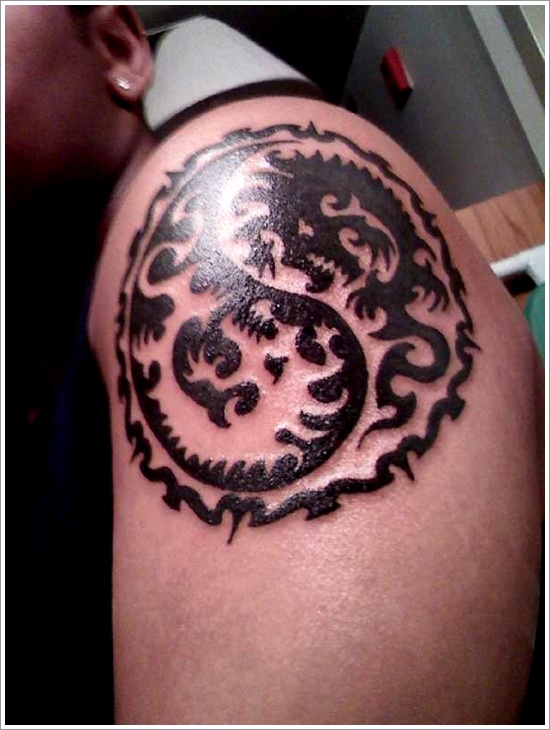 Tatuaggio sul deltoide il disegno nero in stile Yin-Yang