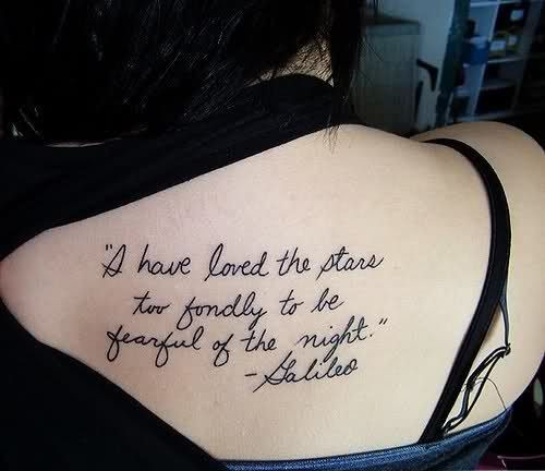 Thin dark black ink quote lettering upper back tattoo