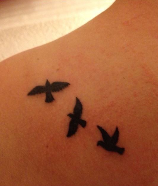 Drei schwarze kleine Vögel Tattoo auf Mädchenkörper