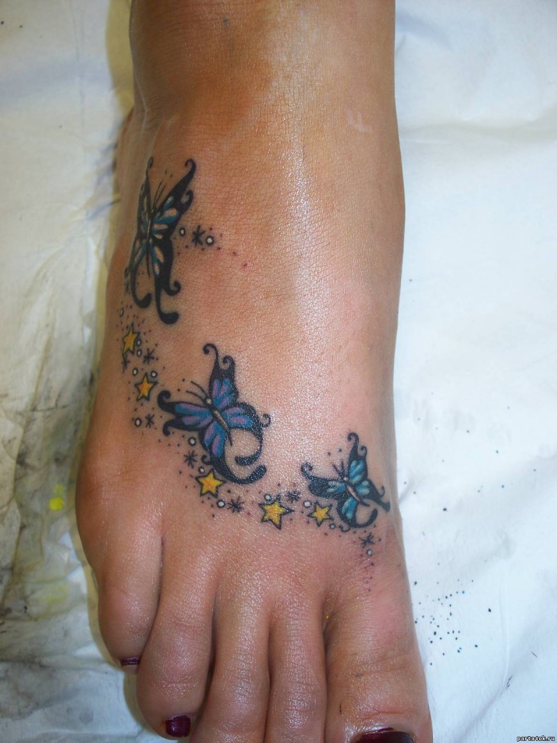 Three blue painted butterflies on foot tattoo