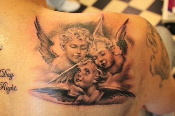 Three cherubs tattoo on shoulder blade