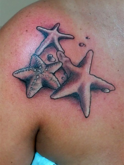 Three great gray-ink starfish tattoo on chest