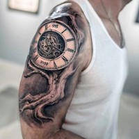 Tatuaje en el brazo, árbol torcido seco con reloj grande