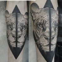 3D like black ink forearm tattoo of split lion head by Valentin Hirsch