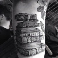 3D like black ink very detailed old magical books tattoo on forearm
