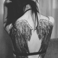 Tatuaje en el brazo, alas con montón de plumas