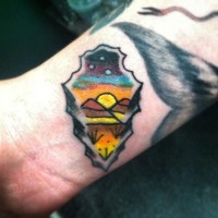 Tatuaje en la muñeca,
 punta de flecha con paisaje precioso