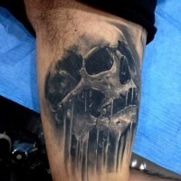 3D like little black ink corrupted skull tattoo on arm