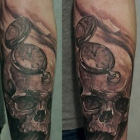 Tatuaje en el antebrazo, cráneo humano antiguo con reloj de bolsillo