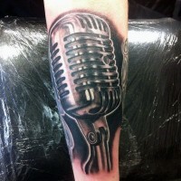 3D like very detailed colored vintage microphone tattoo on arm