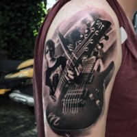 Tatuaje en el brazo,
músico hermoso con guitarra eléctrica