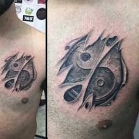 Tatuaje en el pecho,  símbolo famoso yin yang debajo de la piel rasgada