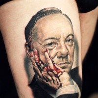 3D real photo like colored man portrait tattoo on thigh with bleeding hand