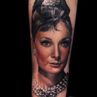 Tatuaje en el antebrazo, retrato realista de señora elegante con joyas