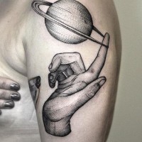 Tatuaje en el brazo, mano con planeta en el dedo, diseño volumétrico
