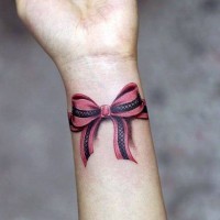 Tatuaje en la muñeca,
lazo de colores rosa y negro volumétrico