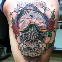 3D realistic extreme themed skull with flowers and lettering tattoo on thigh