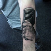 Tatuaje en el antebrazo, mano con micrófono, colores negro blanco