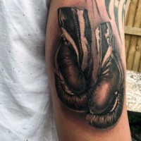 Tatuaje en el brazo,
guantes de boxeo grises simples