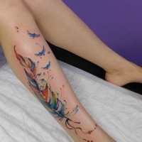 3D style beautiful colored feather tattoo on leg stylized with birds
