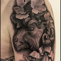3D style black ink shoulder tattoo of goat with ribbon and leaves